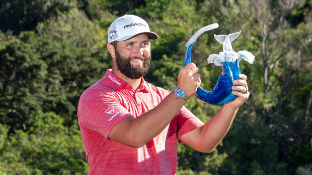 Jon Rahm hoists the trophy on the 18th hole during the final round of the Sentry Tournament of Champions golf tournament at Kapalua Resort - The Plantation Course. 